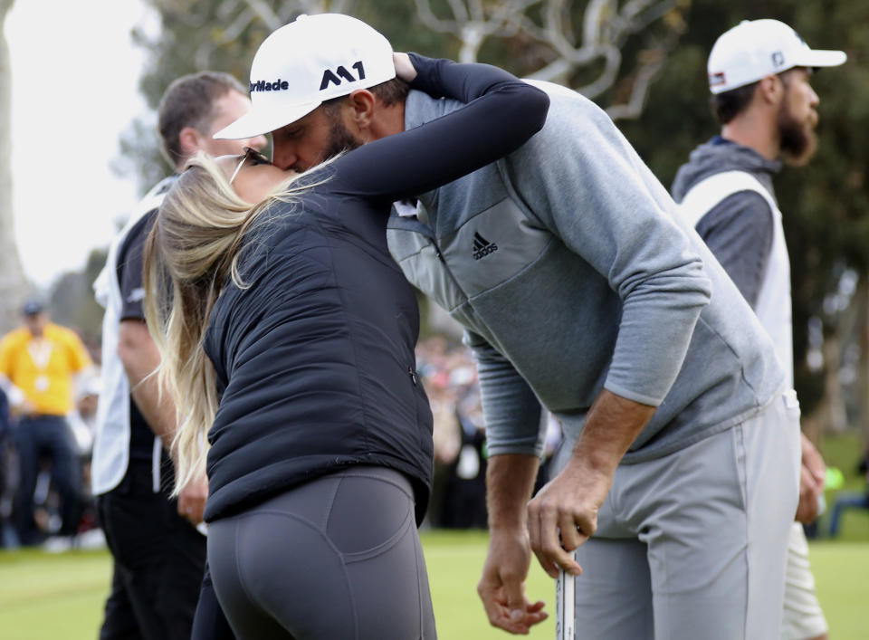 Dustin Johnson kisses his wife Paulina Gretzky on the 18th green after winning the Genesis Open golf tournament at Riviera Country Club on Sunday, Feb. 19, 2017, in the Pacific Palisades area of Los Angeles. (AP Photo/Ryan Kang)