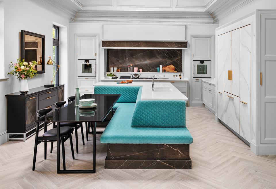 Kitchen island ideas featuring turquoise banquette seating and a black dining table in a large white scheme.