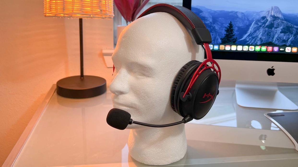  A HyperX Cloud Alpha Wireless gaming headset on a glass desk. 