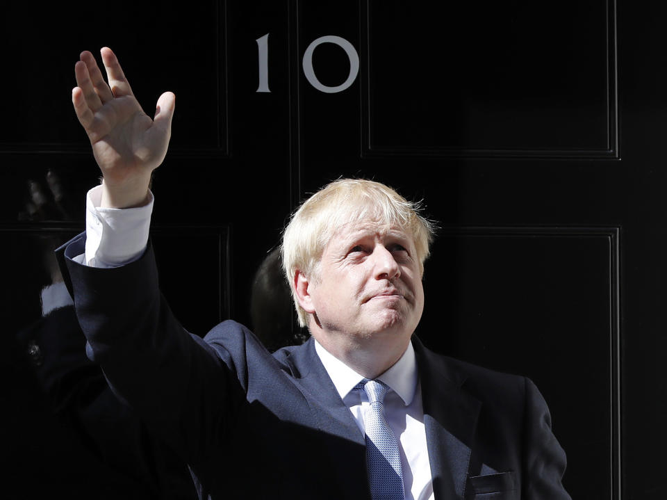 Britain's new Prime Minister Boris Johnson waves from the steps outside 10 Downing Street, London, Wednesday, July 24, 2019. Boris Johnson has replaced Theresa May as Prime Minister, following her resignation last month after Parliament repeatedly rejected the Brexit withdrawal agreement she struck with the European Union. (AP Photo/Frank Augstein)