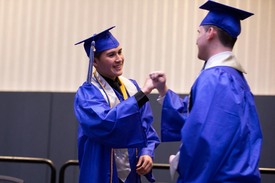 South High School valedictorian Juan Gomez congratulates fellow classmates as they receive their diplomas in 2021 at the the Greater Columbus Convention Center during Columbus City Schools' first in-person graduation in two years due to the COVID-19 pandemic.