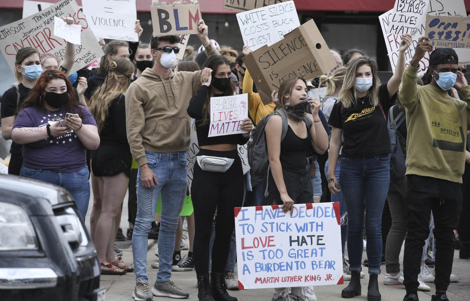 Protesters hold signs at the corner of Chicago Ave. and Washington Street in Naperville, Ill., Monday, June 1, 2020. Protests were held throughout the country over the death of George Floyd, a black man who died after being restrained by Minneapolis police officers on May 25. (Mark Welsh/Daily Herald, via AP)