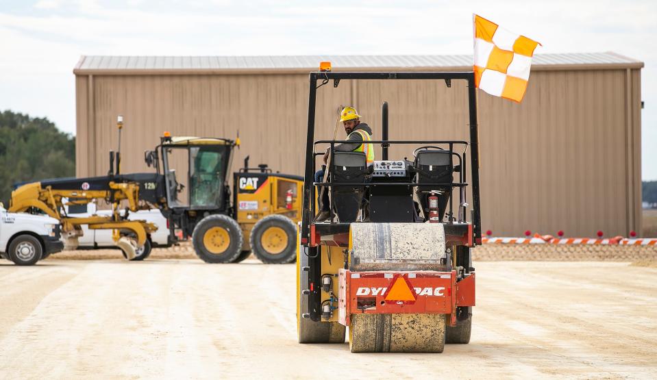 A Ranger Construction worker uses a roller to compact the 10 inches of lime rock as part of an apron project at Ocala International Airport in 2021.