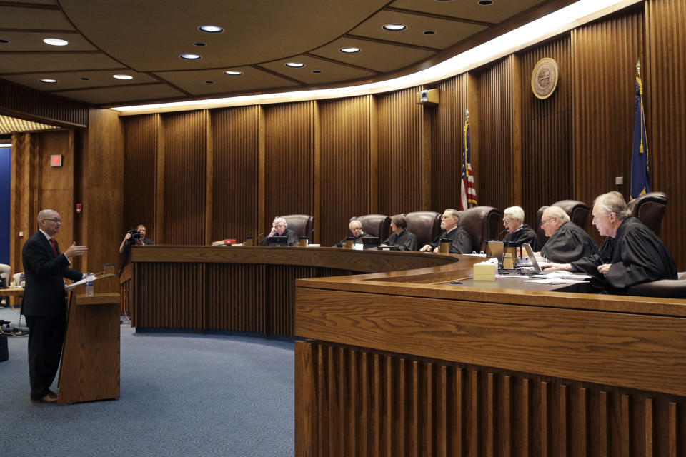 FILE - In this May 9, 2019 photo, State of Kansas attorney Toby Crouse, left, presents his case before the Kansas Supreme Court during oral arguments in a school funding case in Topeka, Kan. Kansas' highest court has signed off on an increase in spending on public schools that the Democratic governor pushed through the Republican-controlled Legislature. But the justices declined in their ruling Friday to close the protracted education funding lawsuit that prompted their decision. The school finance law boosted funding roughly $90 million a year. The court said it wants to ensure that the state keeps its funding promises. (AP Photo/Charlie Riedel, File)