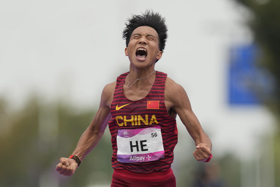 China's He Jie reacts as he crosses the finish line to win the men's marathon at the 19th Asian Games in Hangzhou, China, Thursday, Oct. 5, 2023. (AP Photo/Lee Jin-man)