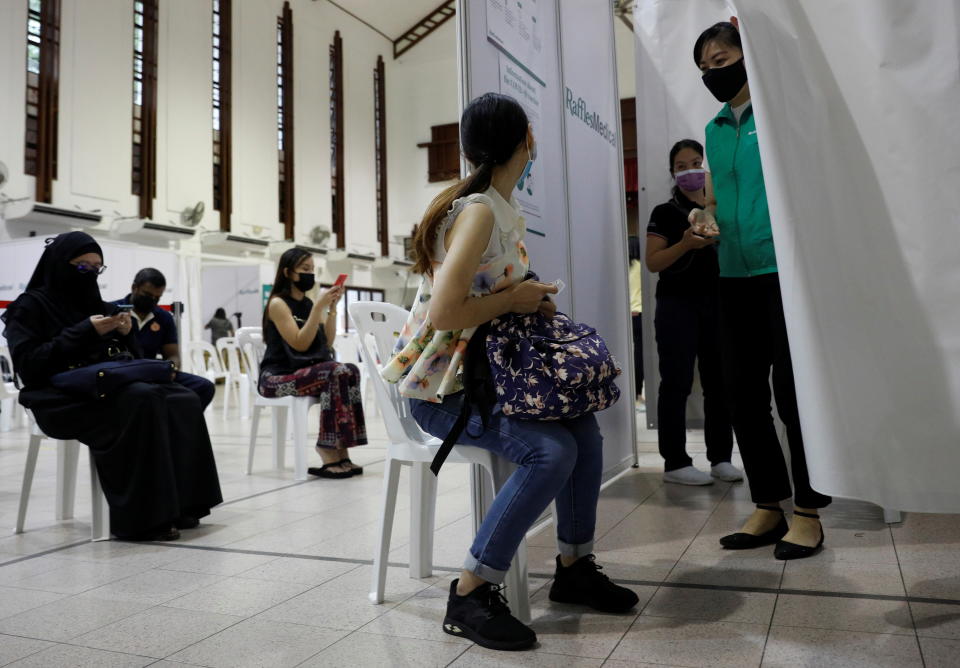 Healthcare workers take their COVID-19 vaccinations in Singapore.