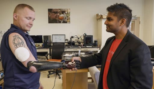 The new technology could allow the retired veteran to simultaneously clasp the hands of his two children