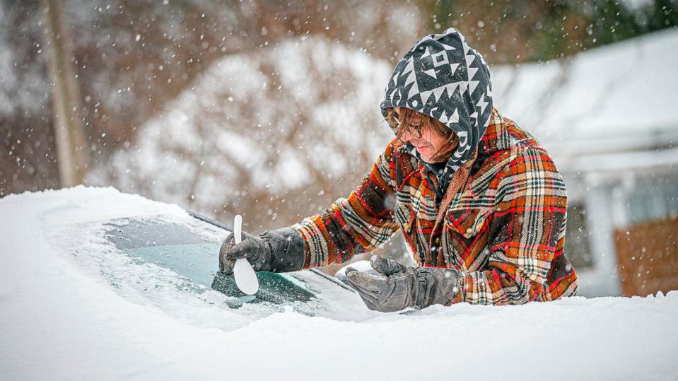 PHOTO: Daniel Cole uses a plastic spoon to clear ice from the front of his vehicle in downtown Florence, Ala., Monday, Jan. 15, 2024. (Dan Busey/The Times Daily via AP)