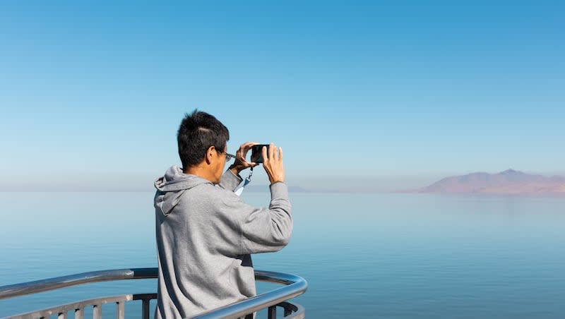 A tourist takes a photo from an overlook at Great Salt Lake State Park in Magna on Oct. 6, 2023.