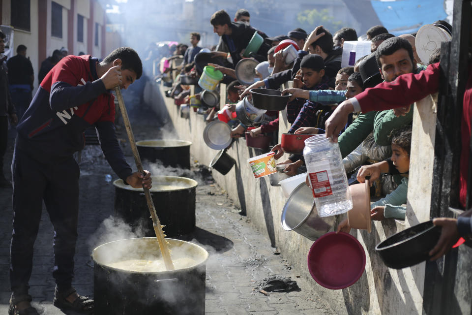 FILE - Palestinians line up for a free meal in Rafah, Gaza Strip, Wednesday, Dec. 20, 2023. Israel and Hamas have been at war for 100 days. The war already is the longest and deadliest between Israel and the Palestinians since Israel’s establishment in 1948, and the fighting shows no signs of ending.(AP Photo/Hatem Ali, File)