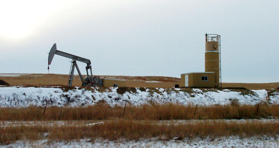 FILE - This Feb. 28, 2012 file photo shows an oil well near Sidney, Mont. Sidney is experiencing a boom spurred by companies seeking to extract oil from the massive Bakken formation beneath western North Dakota and eastern Montana. Prosecutors have netted a string of guilty pleas among the suspects in an interstate drug trafficking case that's highlighted the criminal underside of an oil boom sweeping the Northern Plains. (AP Photo/Matthew Brown, File)