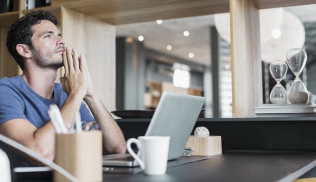 Pensive man at laptop in home office