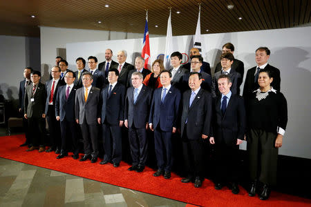 International Olympic Committee (IOC) President Thomas Bach(C), the National Olympic Committee (NOC) of the Republic of Korea (ROK), the NOC of the Democratic People’s Republic of Korea (DPRK), and a delegation from the PyeongChang 2018 Organising Committee (POCOG) pose for a group photo at the IOC headquarters in Lausanne, Switzerland, January 20, 2018. REUTERS/Pierre Albouy