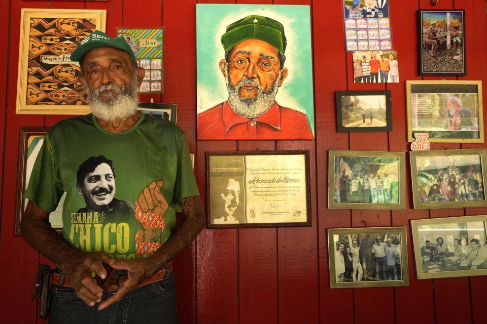 Rubber-tapper Raimundo Mendes de Barros, cousin of legendary rubber tapper leader and environmentalist Chico Mendes, stands near a wall at his house in the Chico Mendes Extractive Reserve, in Xapuri, Acre state, Brazil, Wednesday, Dec. 7, 2022. Thanks to the rubber tappers movement, he said, people now have roads and electricity, and walk around on an equal footing with city residents. (AP Photo/Eraldo Peres)