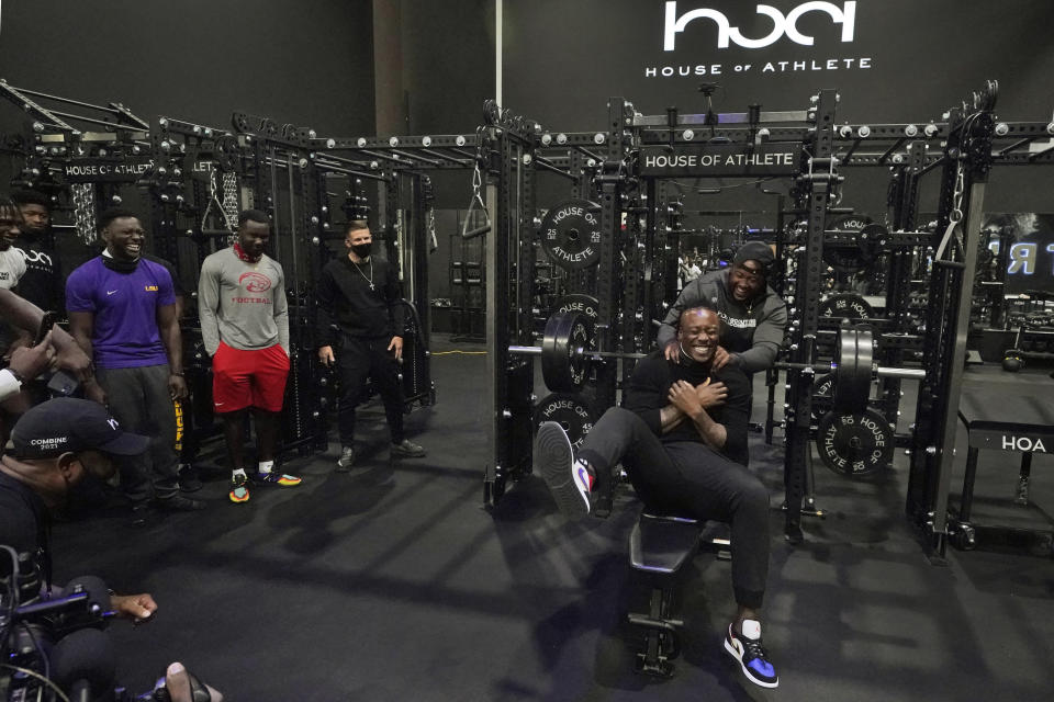 House of Athlete Scouting Combine founder and former NFL player Brandon Marshall, right foreground, is congratulated by Isaiah Ross after Marshall completed a series of bench presses for the combine participants on the second day of the House of Athlete Scouting Combine, Thursday, March 4, 2021, in Weston, Fla. (AP Photo/Wilfredo Lee)