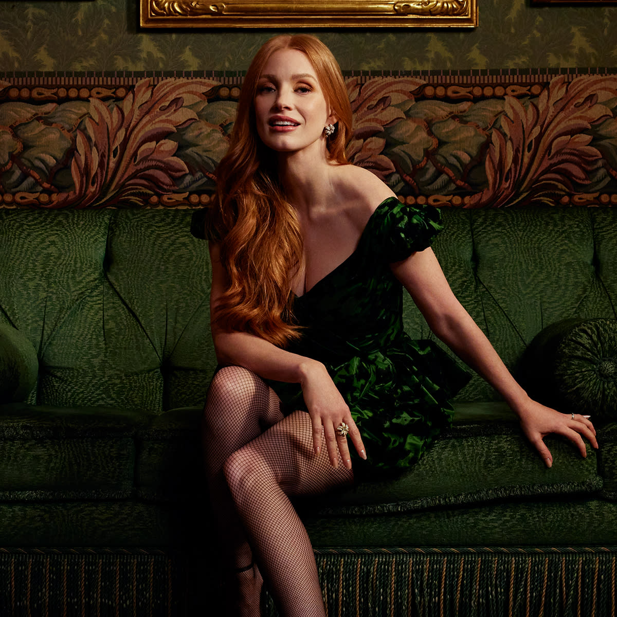  Jessica Chastain leaning on a green brocade couch 