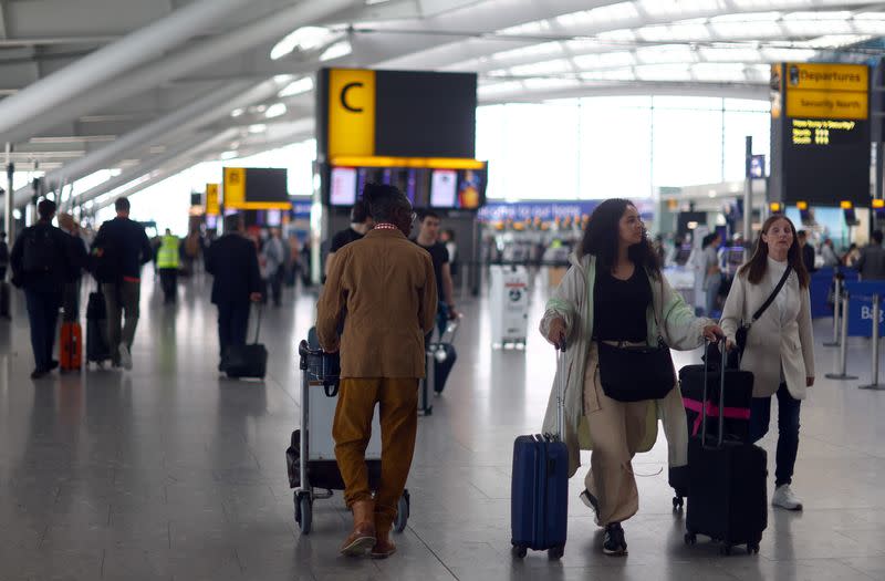 FILE PHOTO: Passengers wait at Heathrow Terminal 5 airport