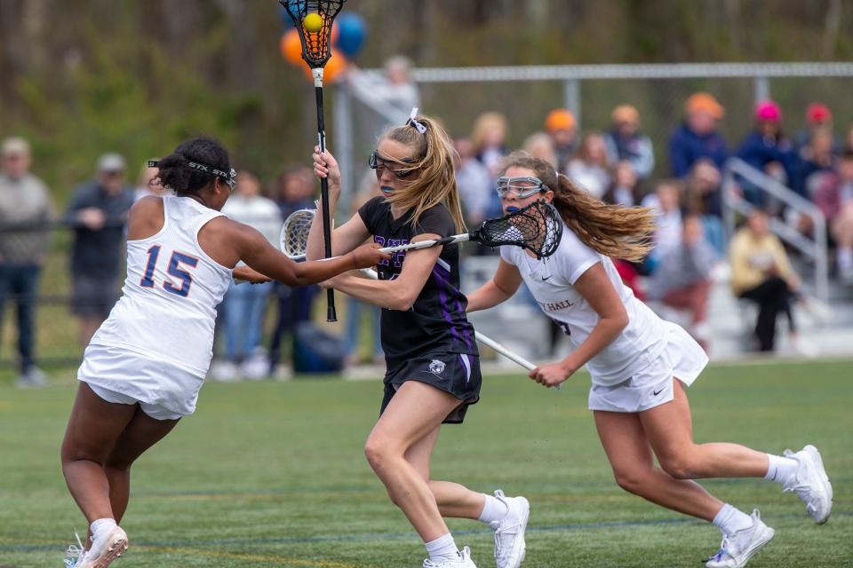 Rumson-Fair Haven's Rachel James (#19, center) is surrounded by Trinity Hall's Kiya Martin (#15, left) and Lily Wood (#6, right) Rumson-Fair Haven vs. Trinity Hall lacrosse game at Capelli Sport Complex in Tinton Falls, NJ Thursday, April 21, 2022.