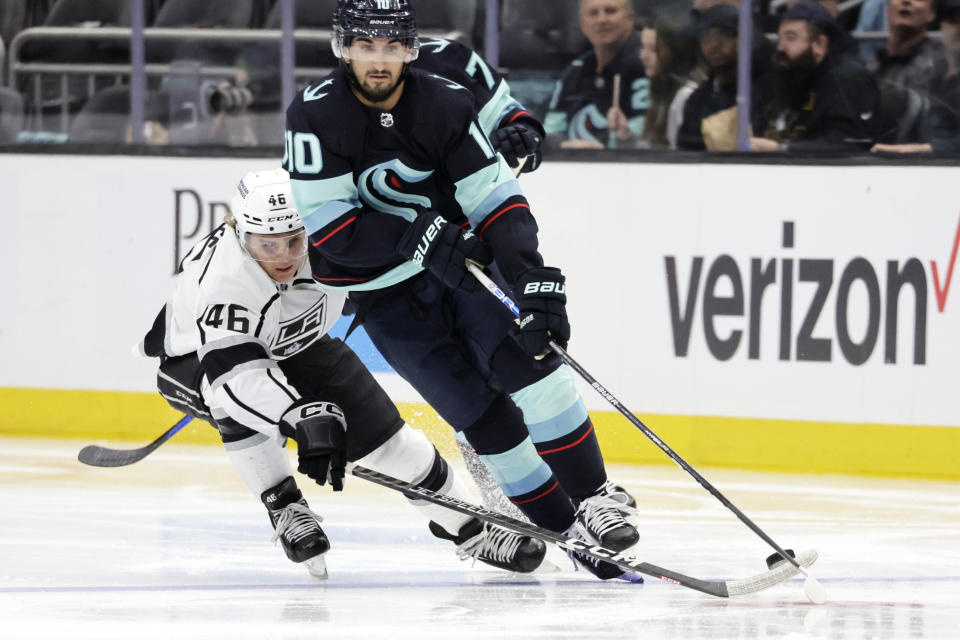 Seattle Kraken center Matty Beniers (10) and Los Angeles Kings center Blake Lizotte (46) compete for the puck during the second period of an NHL hockey game Saturday, April 1, 2023, in Seattle. (AP Photo/John Froschauer)