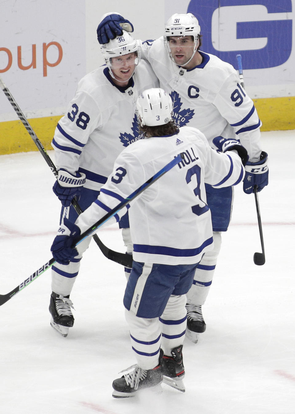 Toronto Maple Leafs' Rasmus Sandin (38) celebrates with John Tavares (91) and Justin Holl (3) after scoring a goal against the Washington Capitals during the third period of an NHL hockey game Monday, Feb. 28, 2022, in Washington. (AP Photo/Luis M. Alvarez)