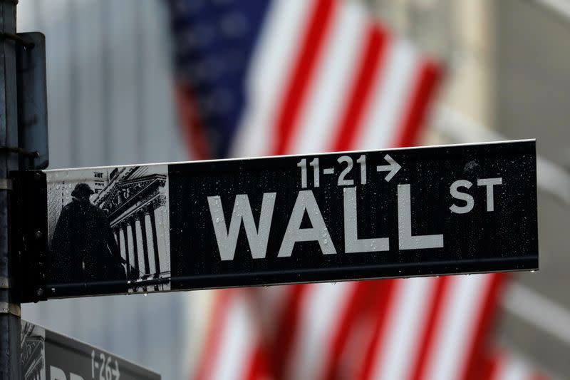 FILE PHOTO: Raindrops hang on a sign for Wall Street outside the New York Stock Exchange in New York