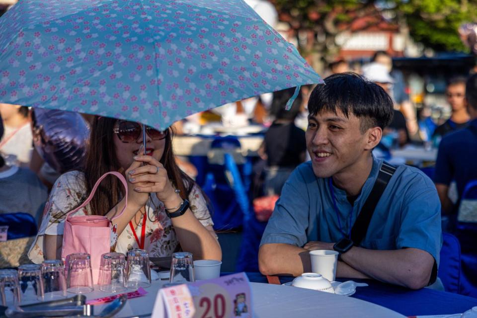 A man and woman smile and talk at a table.