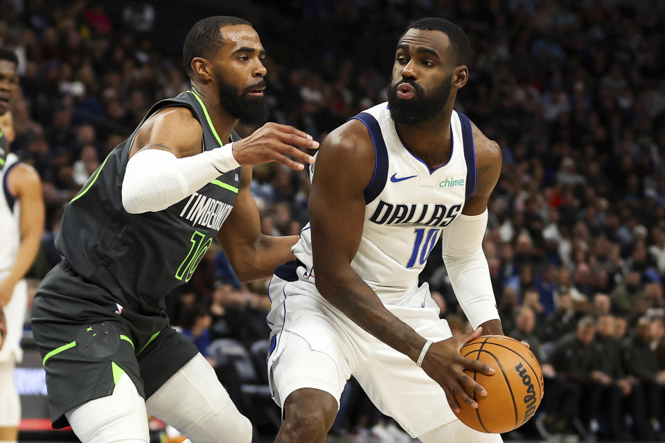 Dallas Mavericks forward Tim Hardaway Jr., right, looks to pass as Minnesota Timberwolves guard Mike Conley (10) defends during the first half of an NBA basketball game, Thursday, Dec. 28, 2023, in Minneapolis. (AP Photo/Matt Krohn)