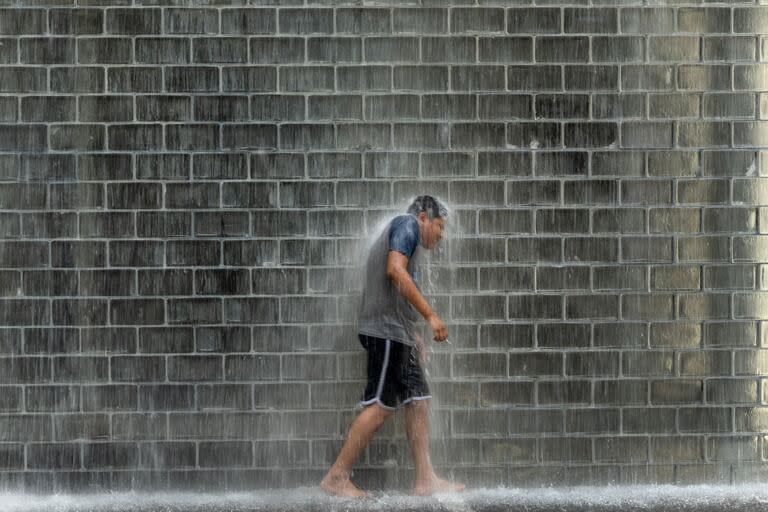 Un niño se refresca en la Fuente de la Corona del Parque del Milenio mientras las temperaturas alcanzan un récord de 97 grados Fahrenheit el 17 de junio de 2024 en Chicago, Illinois. 
