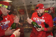 Philadelphia Phillies' Kyle Schwarber, right, and Rhys Hoskins celebrate after the Phillies won a baseball game against the Houston Astros to clinch a wild-card playoff spot, Monday, Oct. 3, 2022, in Houston. (AP Photo/David J. Phillip)