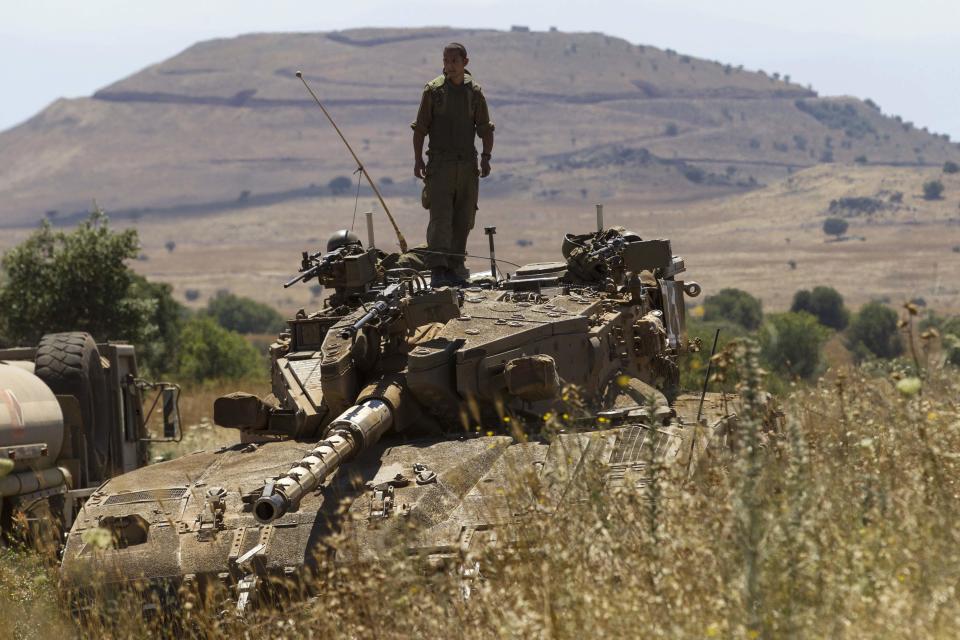 An Israeli soldier stands atop a tank near Alonei Habashan on the Israeli occupied Golan Heights, close to the ceasefire line between Israel and Syria June 22, 2014. (REUTERS/Baz Ratner)