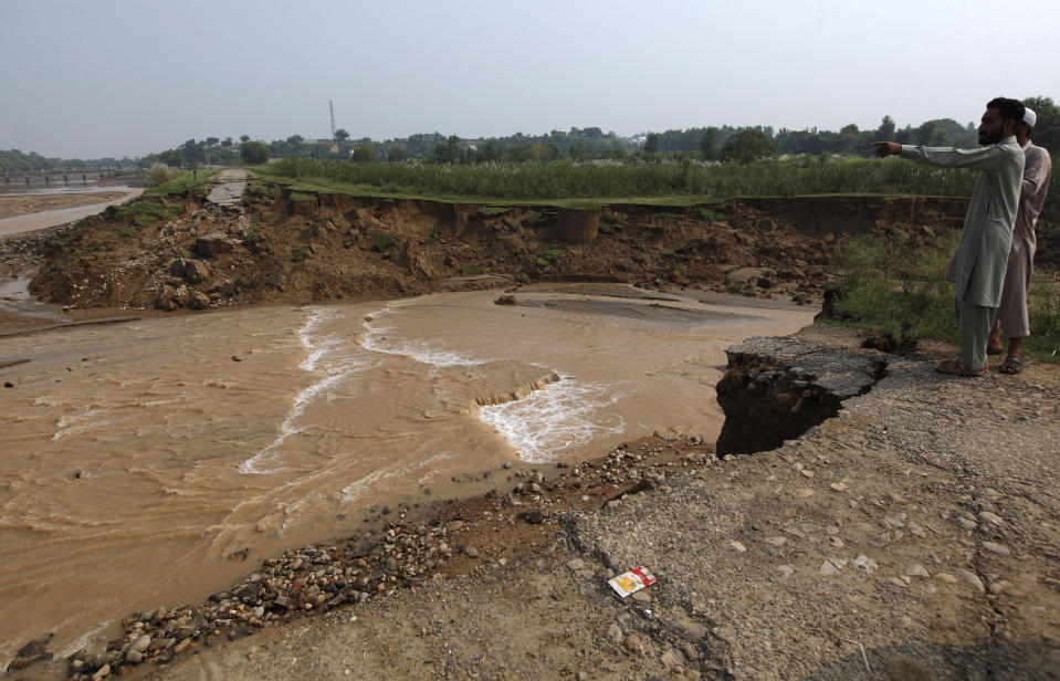 Residents examine damaged portion of a canal washed away by a powerful earthquake, in Jatlan near Mirpur, in northeast Pakistan, Wednesday, Sept. 25, 2019. Thousands of people whose homes were damaged because of a strong earthquake are desperately waiting for the arrival of government help, 22 hours after the 5.8 magnitude tremor struck Pakistan-held Kashmir and elsewhere, killing 25 people and injuring 700. (AP Photo/Anjum Naveed)