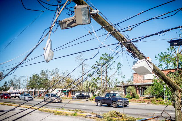 <p>EMILY KASK/AFP via Getty</p> Stock image of a fallen powerline near a home