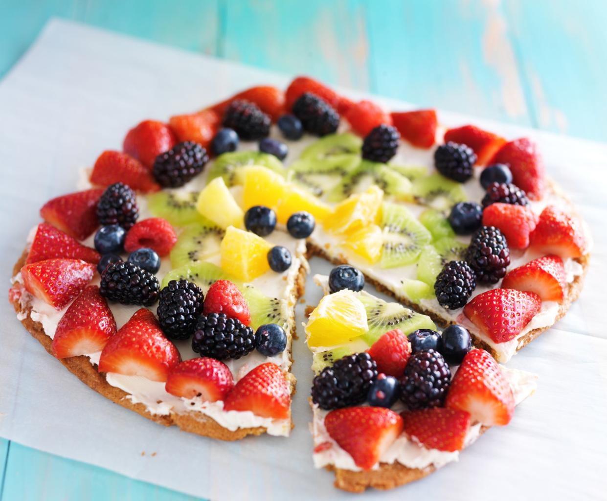 colorful fruit pizza with berries and cream cheese on cookie crust