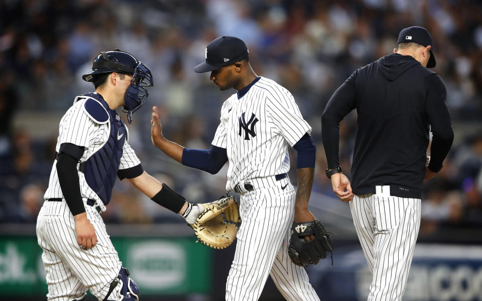 New York Yankees starting pitcher Domingo German gets a pat from the glove of Kyle Higashioka after being removed during the fourth inning of the team's baseball game against the Seattle Mariners Thursday, June 22, 2023, in New York. (AP Photo/Noah K. Murray)