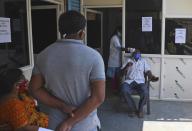 A health worker takes a nasal swab sample of a man to test for COVID-19 at a hospital in Hyderabad, India, Friday, April 16, 2021. India reported more than 200,000 new coronavirus cases Thursday, skyrocketing past 14 million overall as an intensifying outbreak puts a grim weight on its fragile health care system. (AP Photo/Mahesh Kumar A.)