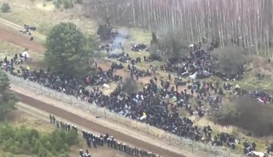 This image made from video provided by Polish Defense Ministry shows an aerial view of migrants and security personnel gathered at the border Kuznica, Poland, Monday, Nov. 8, 2021. Poland increased security at its border with Belarus, the European Union's eastern frontier, after a large group of migrants appeared to be congregating at a crossing point, officials said Monday. A monthslong crisis has seen the Belarusian regime encourage migrants from the Middle East and elsewhere to illegally enter the EU, at first through Lithuania and Latvia and now primarily through Poland. (Polish Defense Ministry via AP)