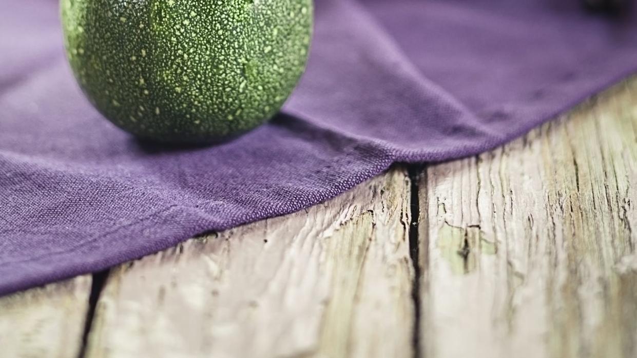 round zucchini on purple cloth and wood