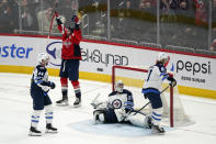 Washington Capitals right wing Tom Wilson celebrates after scoring a game-winning goal in front of Winnipeg Jets defenseman Josh Morrissey (44), goaltender Connor Hellebuyck (37) and left wing Kyle Connor (81) in an overtime period of an NHL hockey game, Tuesday, Jan. 18, 2022, in Washington. Washington won 4-3 in overtime. (AP Photo/Patrick Semansky)