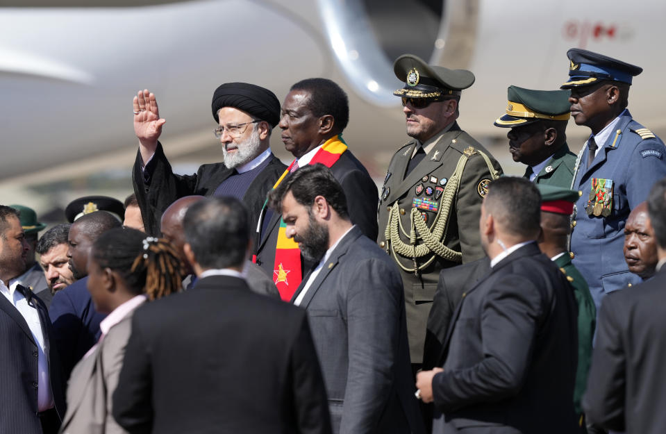 Iran's President Ebrahim Raisi,left, waves while standing next to Zimbabwean President Emmerson Mnangagwa upon his arrival at Robert Mugabe airport in Harare, Zimbabwe, Thursday, July 13, 2023. Iran's president is on a rare visit to Africa as the country, which is under heavy U.S. economic sanctions, seeks to deepen partnerships around the world. (AP Photo/Tsvangirayi Mukwazhi)