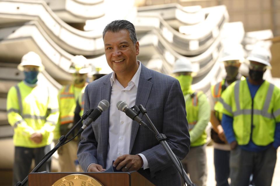 A person smiles at a lectern.