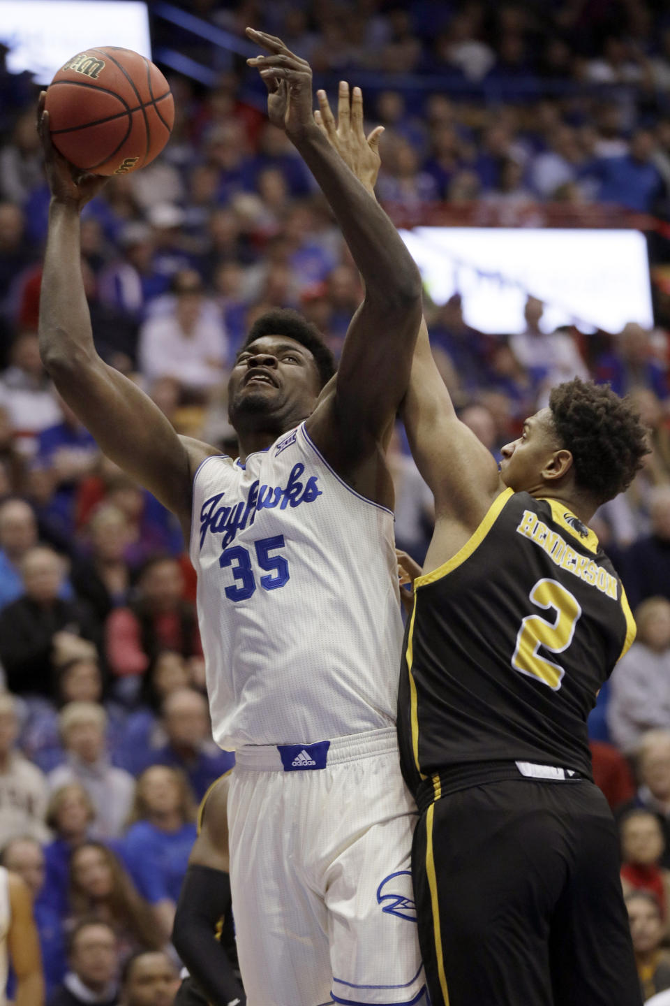 Kansas center Udoka Azubuike (35) shoots while defended by Milwaukee forward Harrison Henderson (2) during the first half of an NCAA college basketball game in Lawrence, Kan., Tuesday, Dec. 10, 2019. (AP Photo/Orlin Wagner)