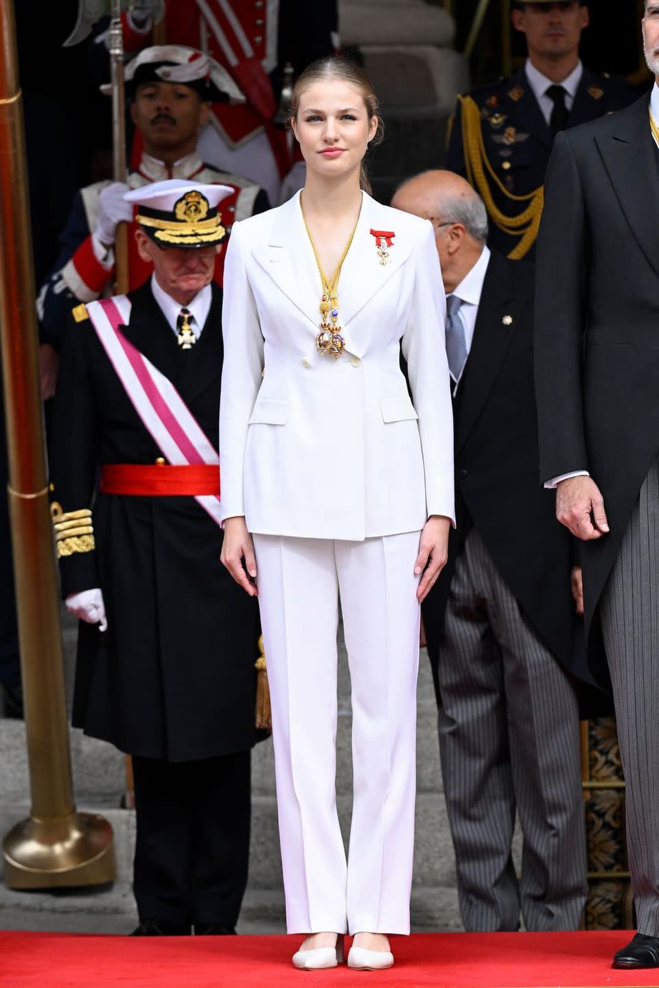 a woman in a white dress standing next to a man in a military uniform