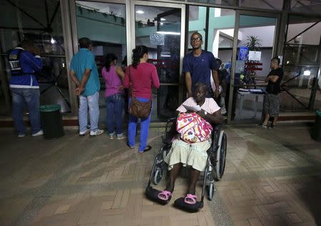 Patients wait outside a clinic that was evacuated after tremors were felt resulting from an earthquake in Ecuador, in Cali, Colombia, April 16, 2016. REUTERS/Jaime Saldarriaga