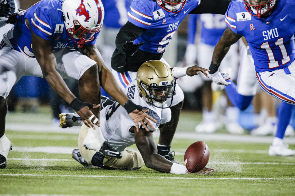 Navy quarterback Dalen Morris (8) fumbles the ball during the first half of the team's NCAA college football game against SMU on Saturday, Oct. 31, 2020, in Dallas. SMU defensive end Gary Wiley, left, recovered the ball. (AP Photo/Brandon Wade)