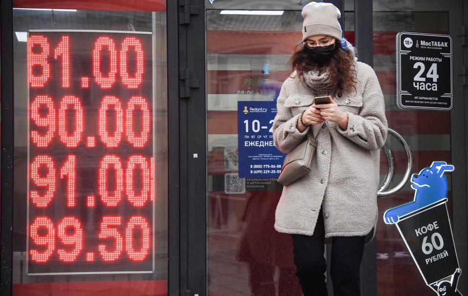 A woman walks past a currency exchange office in central Moscow on February 24, 2022. - Russia's central bank said Thursday in would intervene as the ruble tumbled to a record low and the Moscow Stock Exchange reopened down 14 percent after Moscow launched a military attack on Ukraine, as Russian President Vladimir Putin announced a military operation in Ukraine on Thursday with explosions heard soon after across the country and its foreign minister warning a 