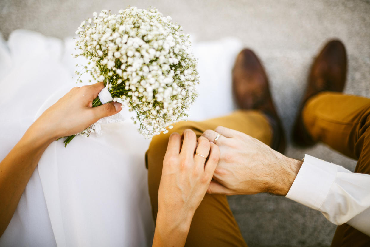 A close-up photo of a bride and groom's hands.