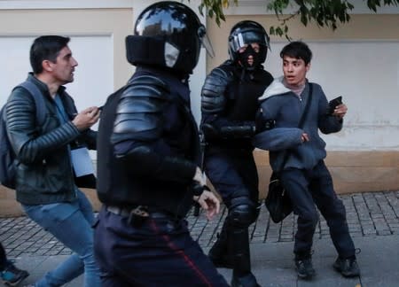 Law enforcement officers detain a man after a rally to demand authorities allow opposition candidates to run in the upcoming local election in Moscow