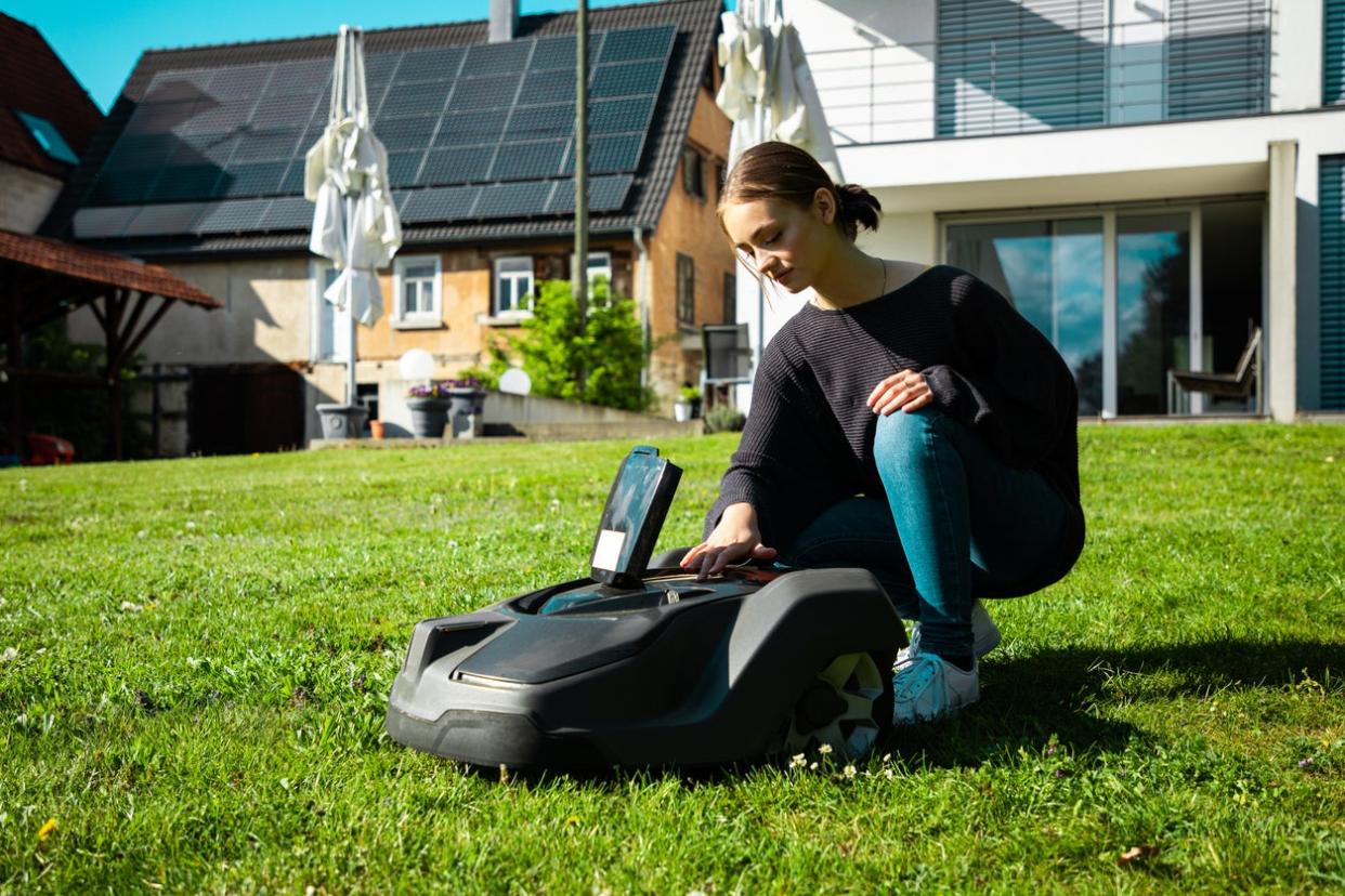 Woman Servicing Her Robot Lawn Mower