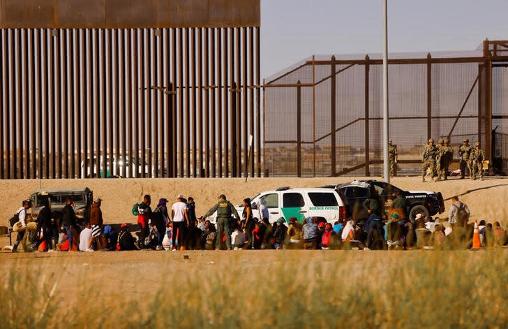 Migrantes son detenidos por agentes de la Patrulla Fronteriza de Estados Unidos después de cruzar el río Bravo para entregarse a solicitar asilo en El Paso, Texas, EEUU, visto desde Ciudad Juárez, México