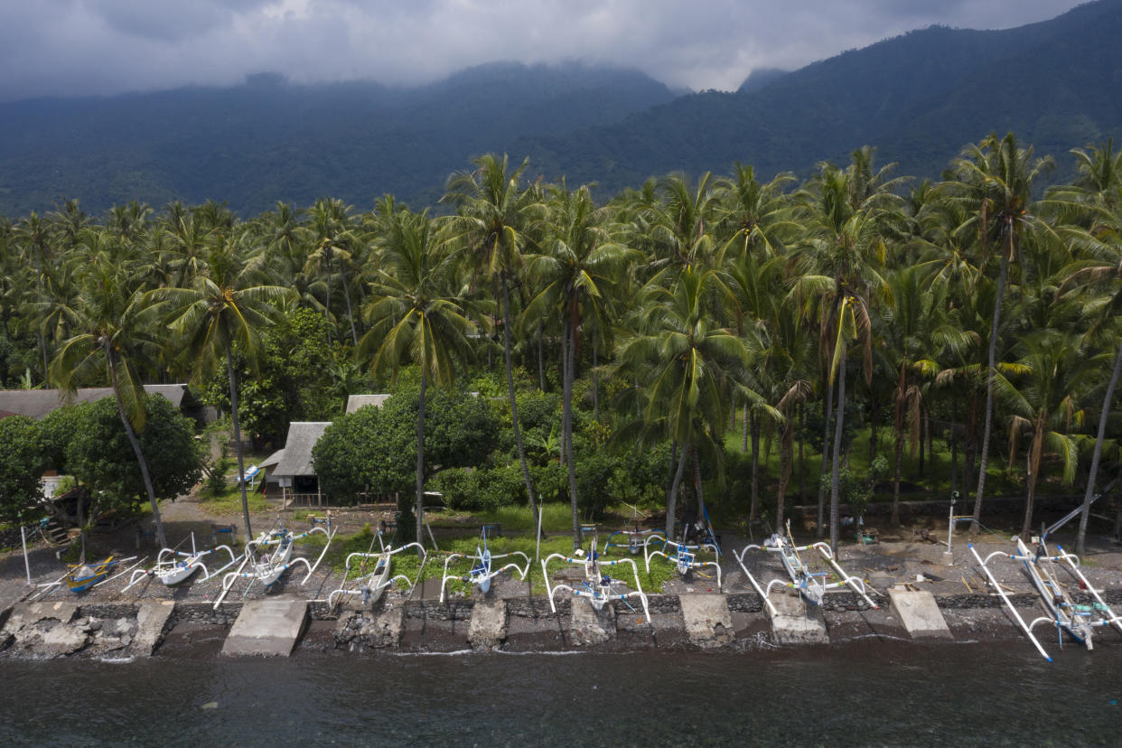 Boats line the coast of Les, Bali, Indonesia, on April 11, 2021. This site is commonly used for aquarium fishing. In the vast archipelago of Indonesia, there are about 34,000 miles (54,720 kilometers) of coastline across some 17,500 islands. That makes monitoring the first step of the tropical fish supply chain a task so gargantuan it is all but ignored. (AP Photo/Alex Lindbloom)